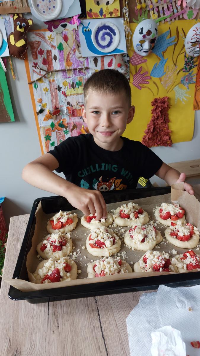 chłopiec przygotywujący do pieczenie słodkie bułeczki