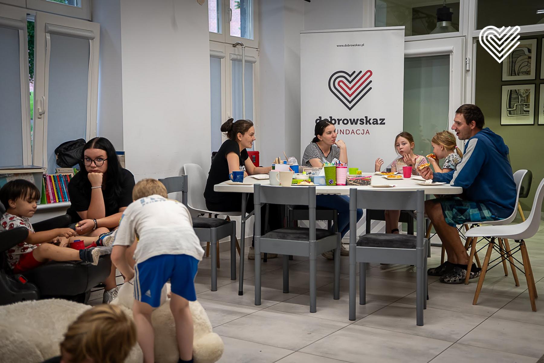 Grupa osób na zajęciach  siedząca przy stole