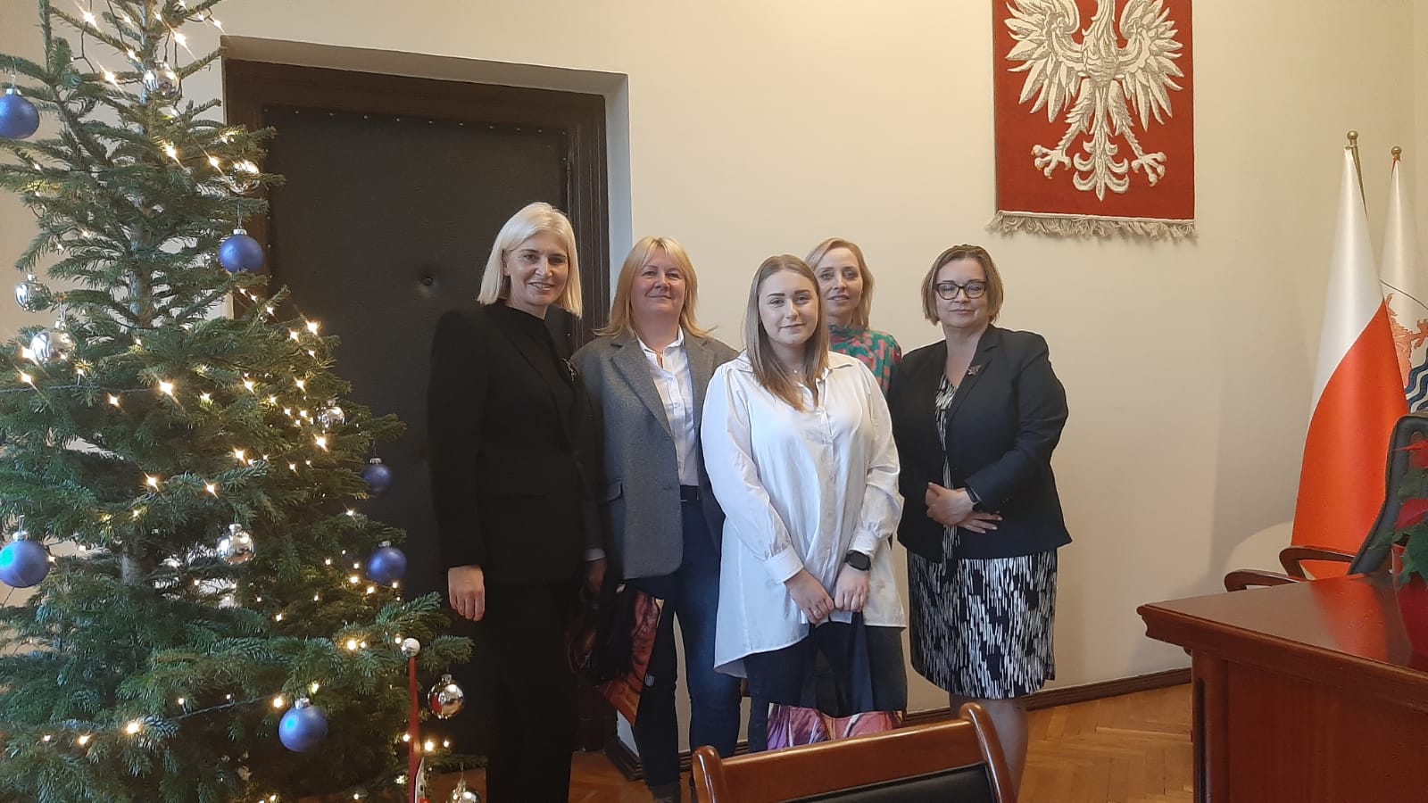 Spotkanie władz miasta z pracownikami socjalnymi MOPR w Urzędzie Miejskim w Słupsku. Uczestnicy uśmiechają się i pozują dumnie do zdjęcia